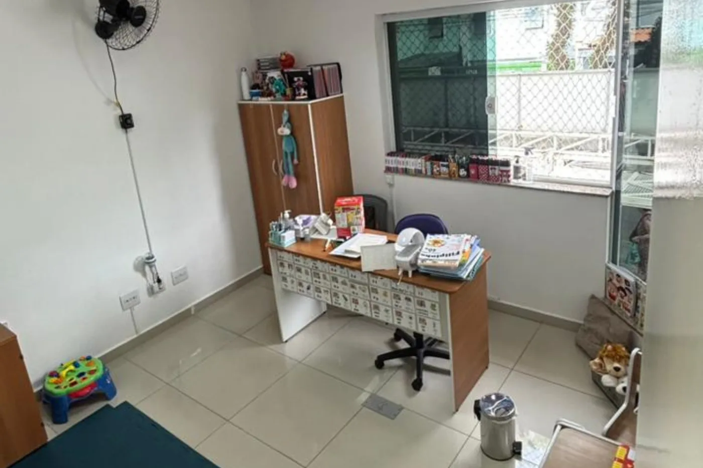 Sala de fonoaudiologia com mesa de atendimento e materiais