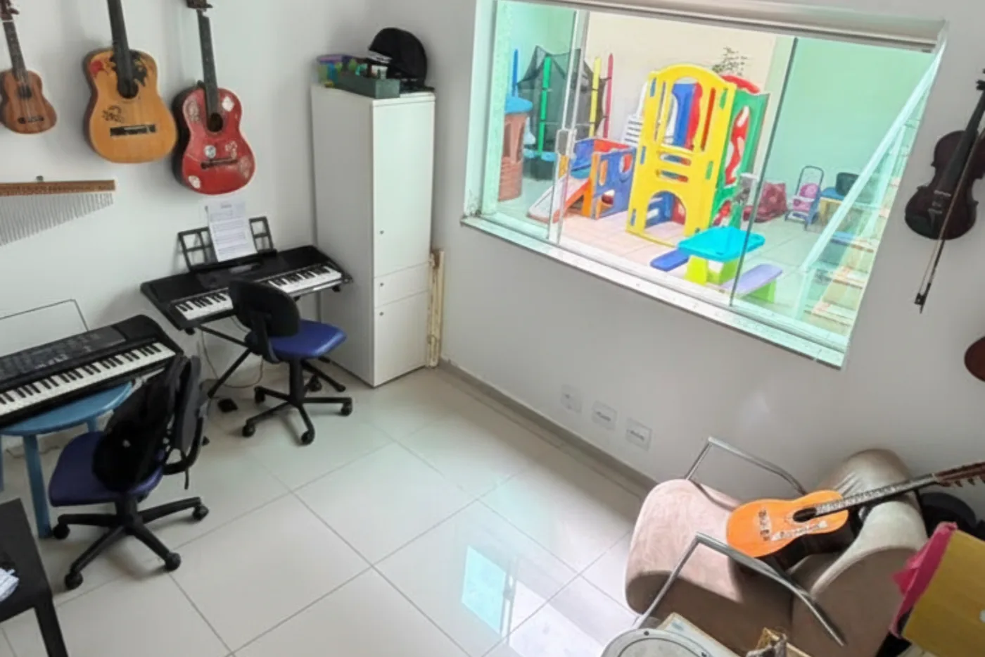 Sala de musicoterapia com violões, teclado e instrumentos